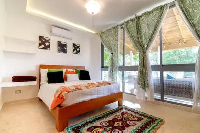 a bedroom with a bed and a large window at Villa loren A3 in Las Terrenas