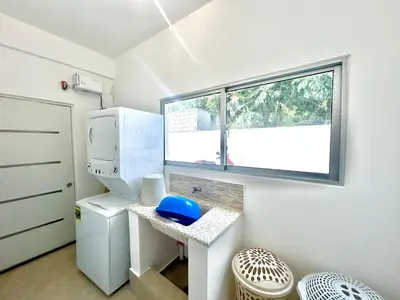 a small kitchen with a refrigerator and a window at Elegante Apartamento A 100 mts la playa de los Minos RSJ in Río San Juan