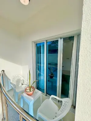 a balcony with two chairs and a table with a plant at Elegante Apartamento A 100 mts la playa de los Minos RSJ in Río San Juan