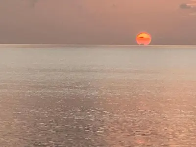 an orange sun in the middle of the ocean at Elegante Apartamento A 100 mts la playa de los Minos RSJ in Río San Juan