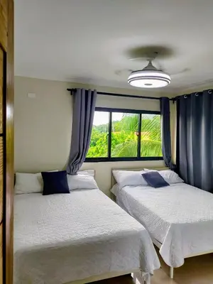 two beds in a room with a window at Apartamento con agua caliente para 9 personas in La Ureña