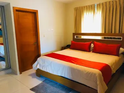 a bedroom with a bed with red pillows and a window at Dpravia Hotel SRL in Baní