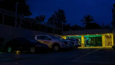 a group of cars parked in a parking lot at night at Dpravia Hotel SRL in Baní