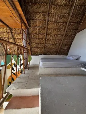 a bedroom with a bed in a straw roof at Blue Beach Eco-Hotel by Sanfabini in Bayahibe