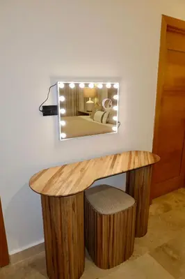 a mirror hanging on a wall above a wooden table at Golden Penthouse by Amar'e in Las Terrenas