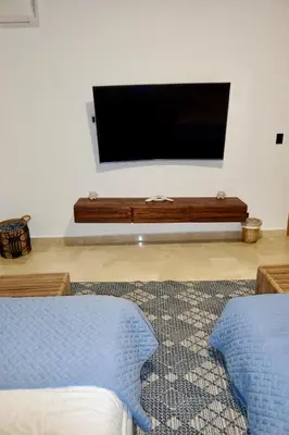 a living room with a flat screen tv on a wall at Golden Penthouse by Amar'e in Las Terrenas