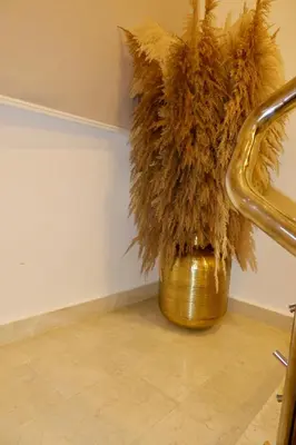 a gold vase with feathers in a corner of a room at Golden Penthouse by Amar'e in Las Terrenas