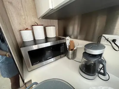 a kitchen with a microwave on a counter at Golden Penthouse by Amar'e in Las Terrenas