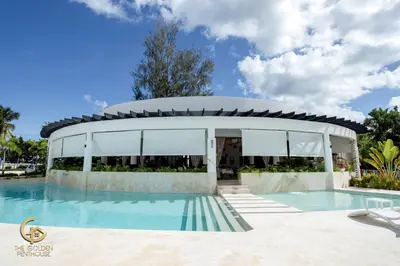 a house with a swimming pool in front of a building at Golden Penthouse by Amar'e in Las Terrenas