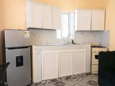 a kitchen with white cabinets and a refrigerator at Guest House A&H in Boca Chica