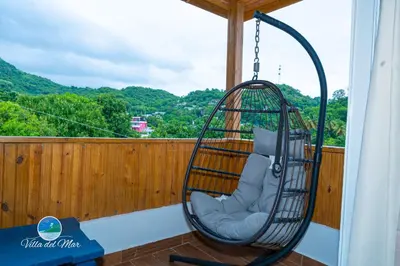 a swinging chair on a balcony with a view at Villa del Mar in Santa Cruz de Barahona