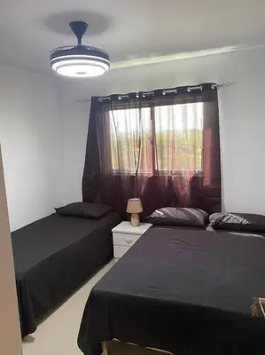 a bedroom with two beds and a window at Luxury Penthouse Santo Domingo W in Santo Domingo