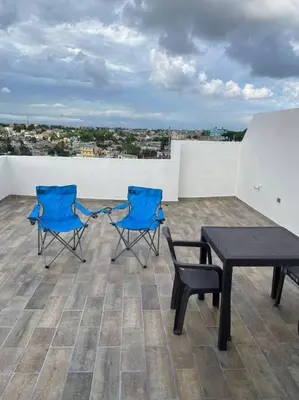 two blue chairs and a table on a roof at Luxury Penthouse Santo Domingo W in Santo Domingo