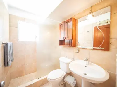 a bathroom with a white toilet and a sink at 2br Caribbean Condo In Cabarete Center in Cabarete