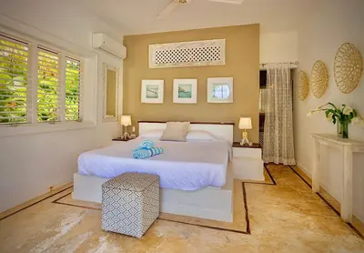 a bedroom with a white bed and two windows at Villa Azulsalado - Frente a la playa in Las Terrenas