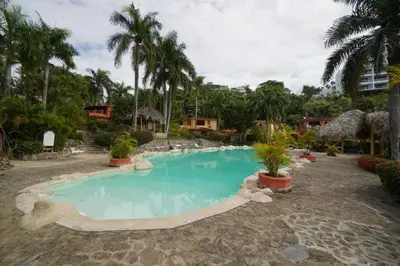 a swimming pool in a resort with palm trees at Villa Playa Bonita, Pool, Tropical Gardens in Las Terrenas