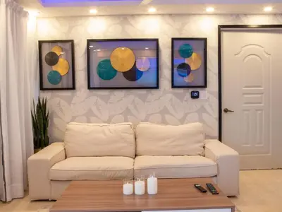 a living room with a couch and four pictures on a wall at Garden Condos 5- Luxurious Apartment In Sosua Center in Sosúa