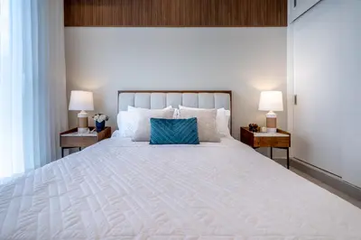 a bedroom with a large white bed with two lamps at Elegant Seaside Villa Steps to Beach & Golf Course in Boca del Soco