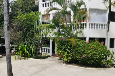 a white building with plants in front of it at Residencial Tropimar Sosua in Sosúa