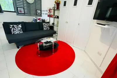 a living room with a red rug and a couch at Residencial Tropimar Sosua in Sosúa