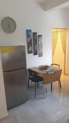 a kitchen with a table and a refrigerator at CasaMia RD B&B in Río San Juan