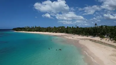 a group of people in the water at a beach at Departamento en las Terrenas a pie de Playa in Las Terrenas