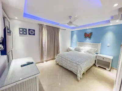 a bedroom with a bed and a blue wall at Garden Condos 43, Modern Condo In Sosa Center in Sosúa