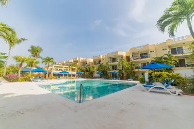 a pool at the resort with chairs and umbrellas at Garden Condos Apt 44 - Comfy 1br Apt In Sosua in Sosúa