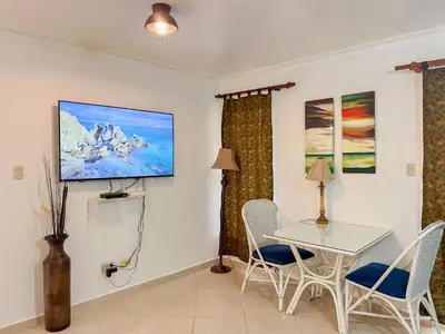 a dining room with a table and chairs and a tv at Garden Condos Apt 44 - Comfy 1br Apt In Sosua in Sosúa