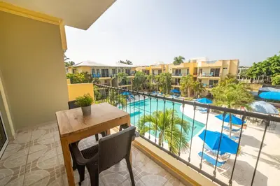 a balcony with a table and chairs and a swimming pool at Garden Condos Apt 35 - Affordable 1br Apt In Sosua in Sosúa