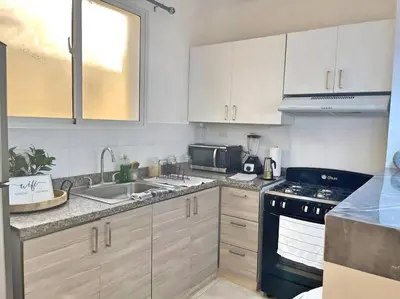 a kitchen with white cabinets and a sink and a stove at Apto 3 Habitaciones Zona Tranquila Con Parqueo in Concepción de La Vega