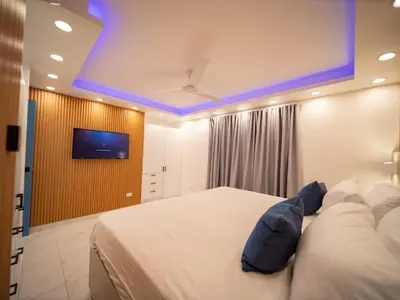 a bedroom with a bed and a tv on a wall at Garden Condos 39, Luxury Apartment In Sosua Town in Sosúa