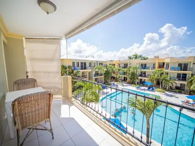 a balcony with a view of a pool and buildings at Garden Condos Apt 30 - Lovely 1br Condo W Pool in Sosúa