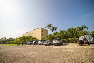 a parking lot with cars parked in front of a building at Garden Condos Apt 30 - Lovely 1br Condo W Pool in Sosúa