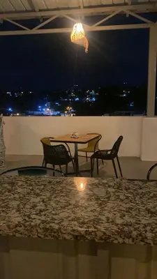 a table and chairs on a balcony at night at Mi lugar de descanso in Moca