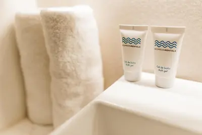 two bottles of sunscreen sitting on a shelf in a bathroom at Beach Homes Punta Cana in Punta Cana