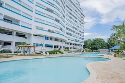 a swimming pool in front of a large building at Xeliter Las Olas Juan Dolio in Guayacanes