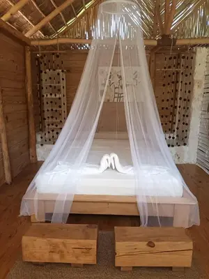 a bed with a mosquito net in a room at Samo Eco Lodge in Las Terrenas