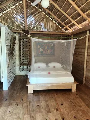 a bed in a room with a net at Samo Eco Lodge in Las Terrenas