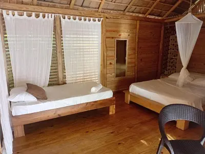 a bedroom with two beds in a wooden cabin at Samo Eco Lodge in Las Terrenas