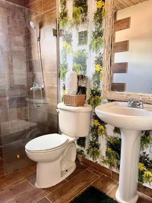 a bathroom with a toilet and a sink at El ATiCO ConstanzaRD in Constanza