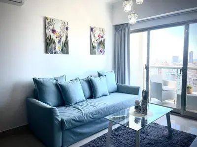 a living room with a blue couch and a glass table at Brand New Luxury 1 BDR Pool-Cine - Saune-WIFI - I 19 in Santo Domingo