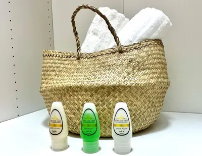 three bottles of soap next to a basket at Deluxe_Suite_1BDR_POOL_GYM_SAUNE in Santo Domingo