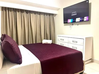 a bedroom with a bed and a flat screen tv at Suite Bolívar 3bdr - Pool - Cine -Saune - SPA- A8 in Santo Domingo