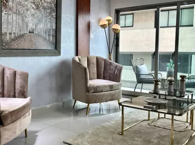 a living room with a chair and a table at Suite Bolívar 3bdr - Pool - Cine -Saune - SPA- A8 in Santo Domingo