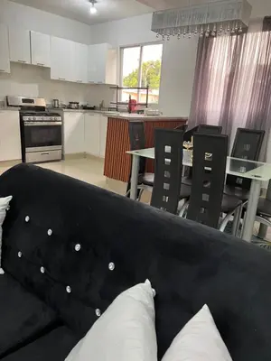 a living room with a couch and a kitchen at alojamiento en san juan de la maguana in SJM