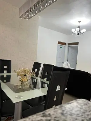a dining room with a glass table and black chairs at alojamiento en san juan de la maguana in SJM