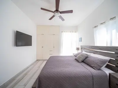 a bedroom with a bed with a ceiling fan at Amazing 2br Villa Near Surfing Beaches in Cabarete