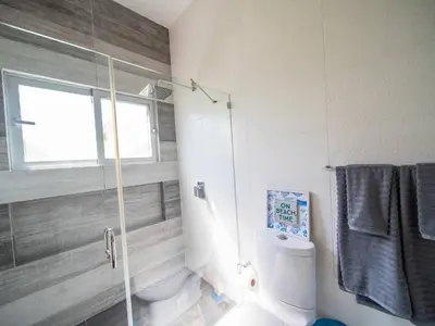 a bathroom with a shower and a toilet and a window at Amazing 2br Villa Near Surfing Beaches in Cabarete