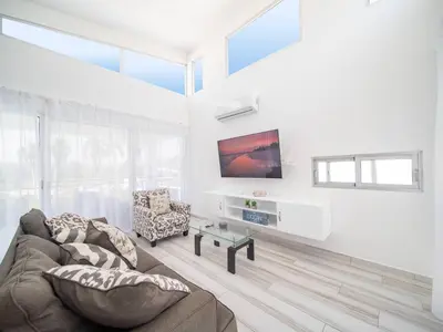 a living room with a couch and a tv at Amazing 2br Villa Near Surfing Beaches in Cabarete